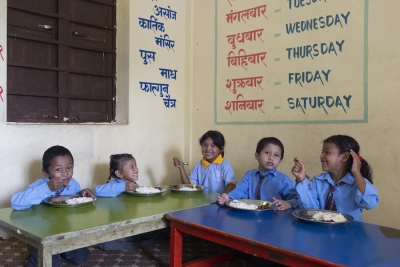 children from Nepal share a meal cooked for them in school. 